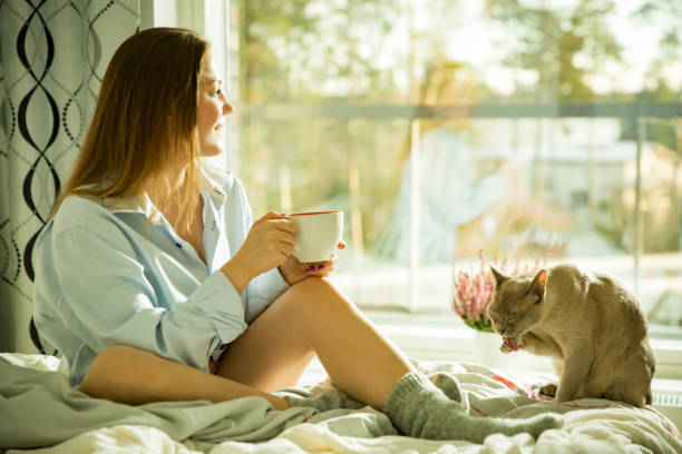 istock Woman sitting at home a bed by the window 1077229692