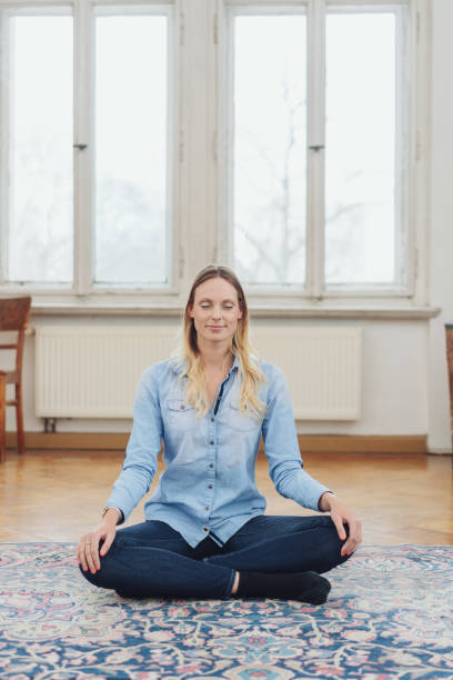 istock Blonde woman sitting cross-legged on floor 1077234866