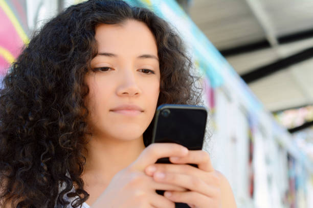 istock Young latin women sending message with smartphone. 1077238522