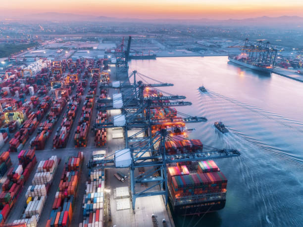 istock Aerial view container ship at sea port and working crane bridge loading container for logistics import  export or transportation concept background. 1077238646
