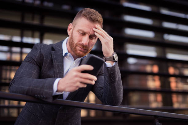 istock Mid adult businessman using phone and having a headache. 1077238830