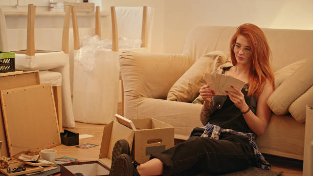 istock Single woman unpacking cardboard boxes in new apartment. 1077240778