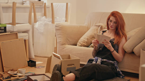 istock Single woman unpacking cardboard boxes in new apartment. 1077241038