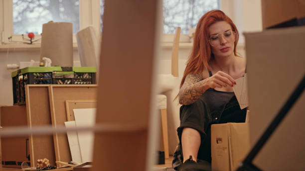 istock Single woman unpacking cardboard boxes in new apartment. 1077241110