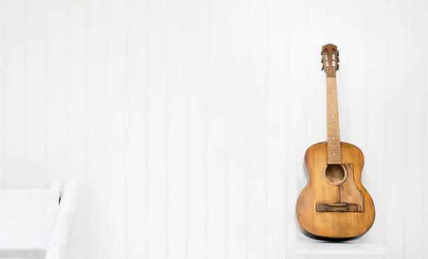 istock Guitar on a white chair and white background. 1077244596