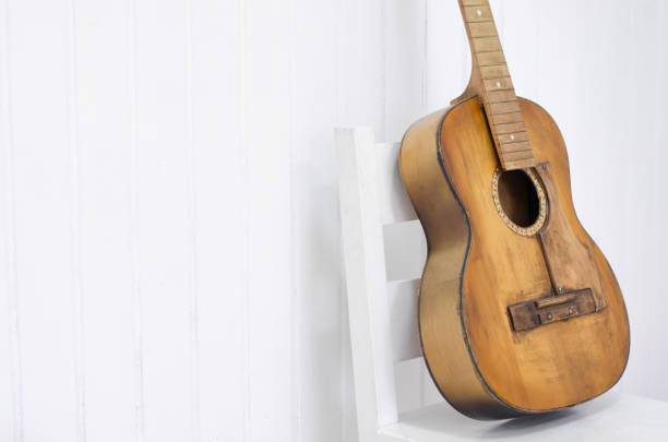 istock Guitar on a white chair and white background. 1077244598