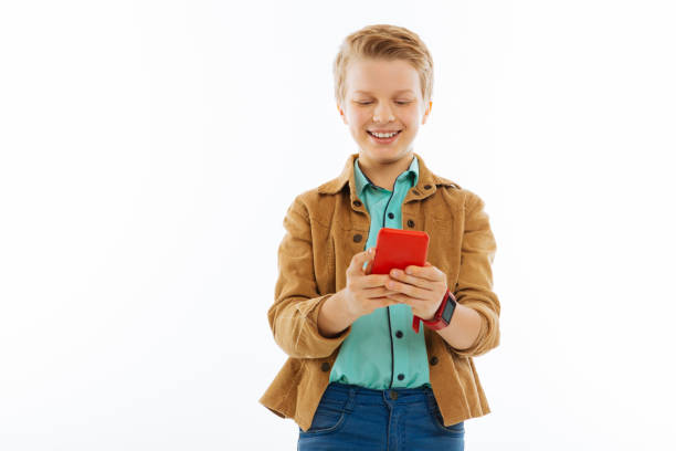 istock Happy nice boy typing a message on his phone 1077248424