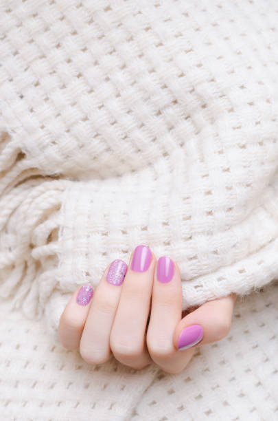 istock Female hand with pink nail design with glitter. 1077249770