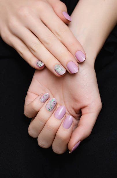 istock Female hand with pink nail design with glitter. 1077249778