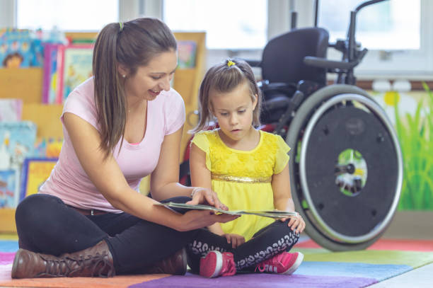 istock A teacher reads to a disabled student 1077252462