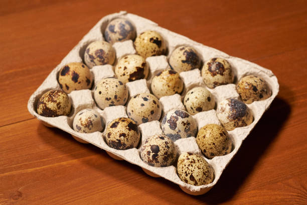istock Quail eggs s in lattice on brown wooden background. Selective focus 1077252688