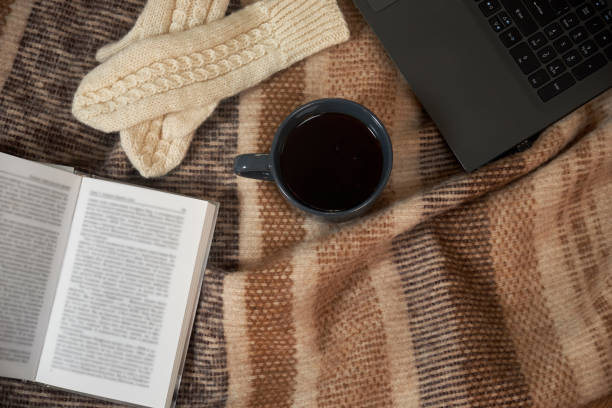 istock A Cup of tea, a book, a laptop and mittens on a blanket 1077255124