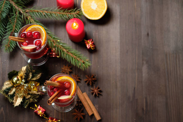 istock Mulled wine on a wooden background with candles, pine branches and Christmas lights. Selective focus.  Copy space 1077257460