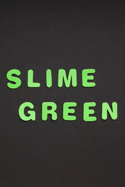 Photo of Slime green writing on black paper background