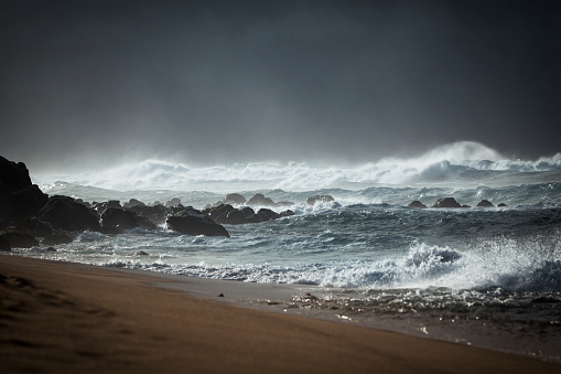 dark storm waves crushing at the beach on maui island, hawaii islands, usa.