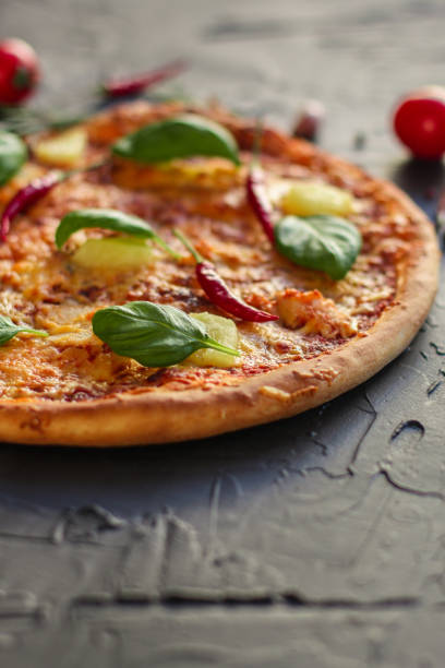 istock pizza, pineapple, chicken, tomato sauce, cheese, basil (pizza ingredients). Hawaiian pizza. Top view. copy space 1077260374