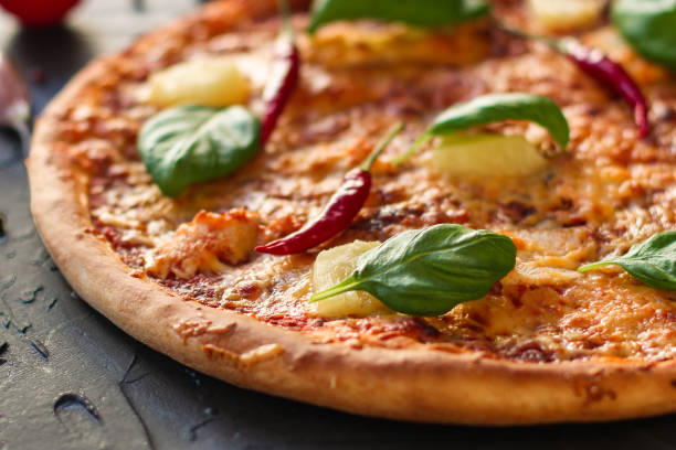 istock pizza, pineapple, chicken, tomato sauce, cheese, basil (pizza ingredients). Hawaiian pizza. Top view. copy space 1077260406
