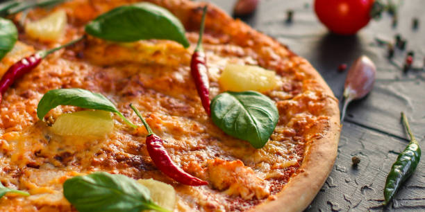 istock pizza, pineapple, chicken, tomato sauce, cheese, basil (pizza ingredients). Hawaiian pizza. Top view. copy space 1077260416