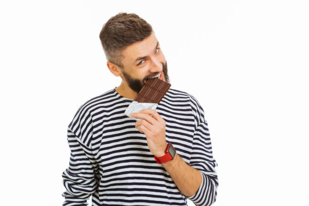 istock Pleasant attractive man eating a chocolate bar 1077260780
