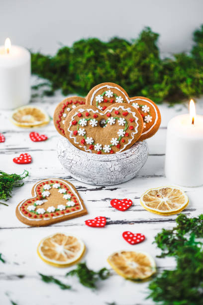 Gingerbread Cookies hearts in a cup, two candles on a white wooden background Valentines day concept