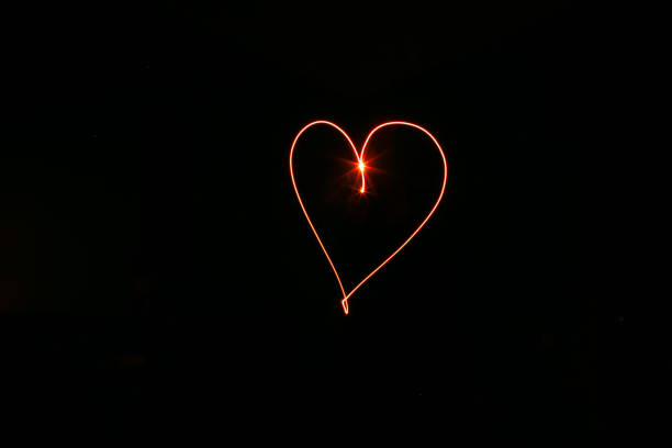 istock long exposure red heart black background 1077262166
