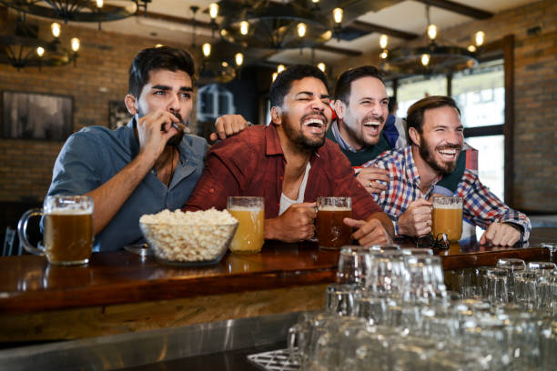 istock Group of young joyful friends having fun while toasting with beer in a pub 1077262462