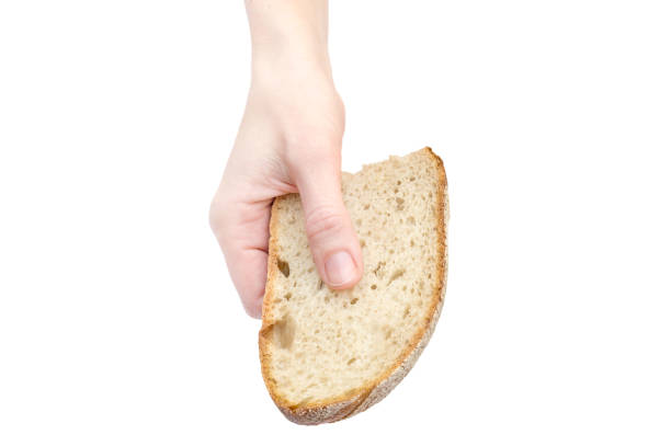 istock Woman's hand holding piece of bread. Isolated on white. 1077263618