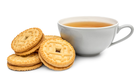 Cup of tea with sandwich cookies on white.