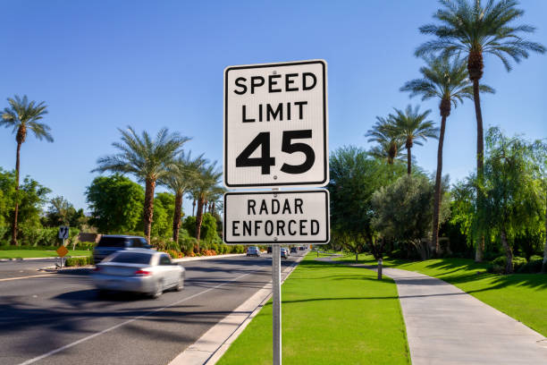 Speed Limit 45 Radar Enforced road sign with passing cars on a California street. stock photo