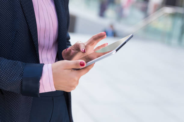 istock Asian Businesswoman Working On Tablet Computer Outside Offic 1077268188