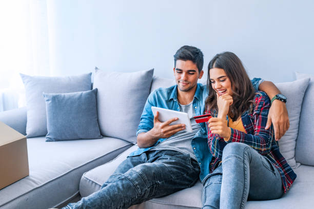 istock Young couple are using digital tablet amid boxes in a new house 1077268252