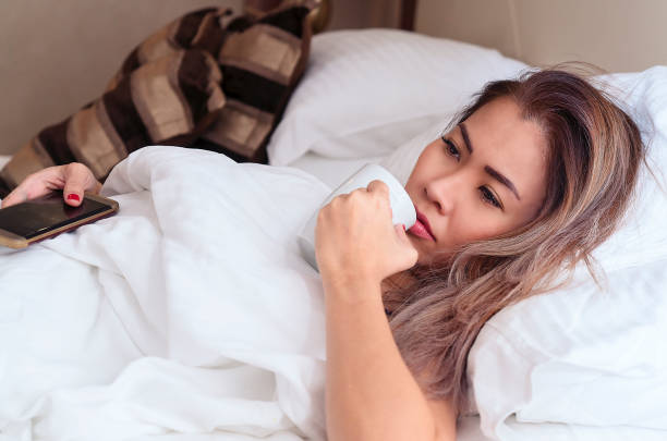 istock Woman feeling sick, having headache, drinking tea - cold and flu 1077270118