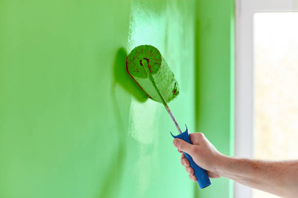 hommes de main peinture mur avec rouleau à peinture. appartement de peinture, rénovation avec de la peinture de couleur verte - painting wall paint paint roller photos et images de collection