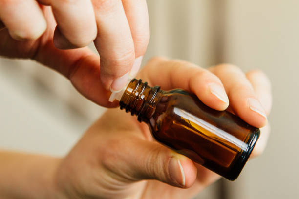 Personne qui détient la bouteille d’huile essentielle - Photo