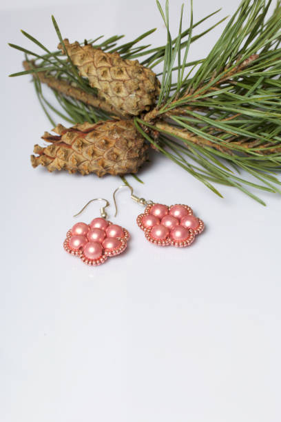 istock Women's earrings from beads among pine branches with cones. On a white background. 1077279336