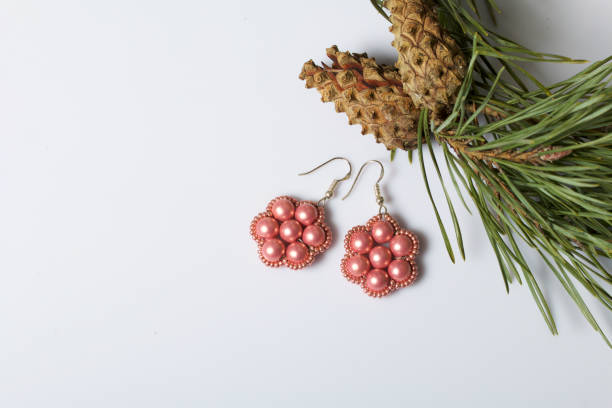istock Women's earrings from beads among pine branches with cones. On a white background. 1077279344