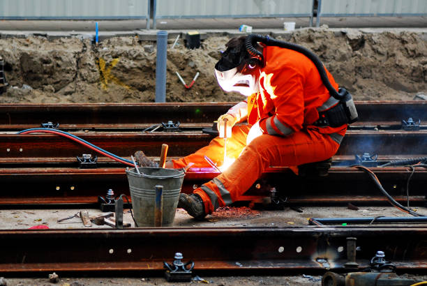 The fascinating way Railroad tracks are welded together Man wearing safety clothing and shield while welding a railway Beam. He is using an oxy-acetylene cutting torch to cut a track rail. This is taken place in Amsterdam. automatic welding torch stock pictures, royalty-free photos & images
