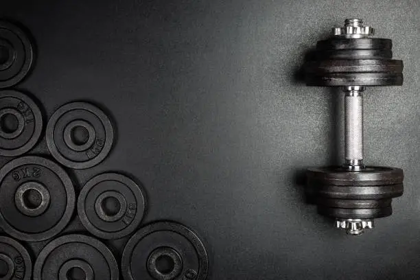 Gym dumbbells with black metal weights 1kg and 2kg on black background with copy sapce, Photograph taken from above.
