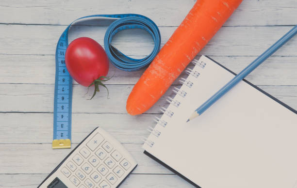 上面ビュー、メモ帳、ジューシーなトマトとニンジン、痩身と健康的な食事の概念。 - instrument of measurement vegetable measuring exercising ストックフォトと画像
