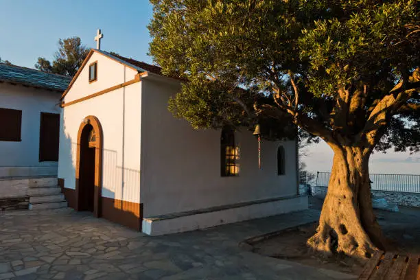 Olive tree and the church of Agios Ioannis Kastri at sunset, famous from Mamma Mia movie scenes, Skopelos Island, Greece