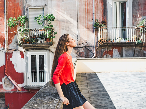 Stylish, young woman on the background of colorful, bright houses of the fabulous city of Naples. Travel and vacation concept