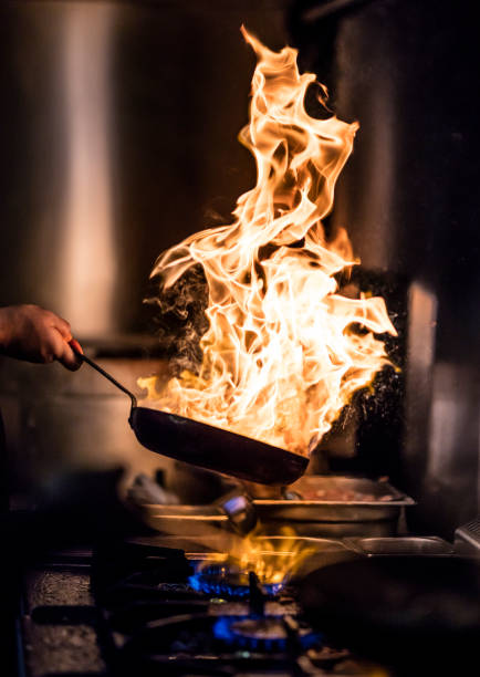 火炎の食事を準備する - chef cooking food pan ストックフォトと画像