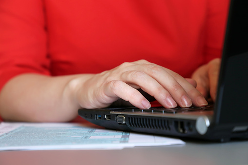 Female hands typing on notebook keyboard closeup, concept of accountant, secretary, businesswoman or personnel agent