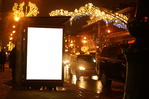 city outdoor billboard mockups Glows in the darkness of the night city Christmas decorations winter on the street garlands glow .