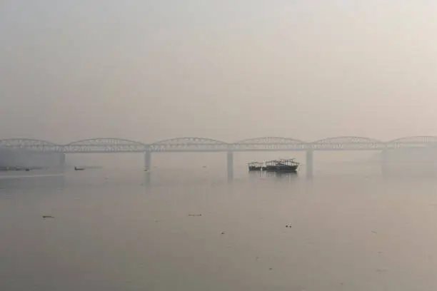 Photo of View of a Ghat (riverfront steps) of sacred river Ganges in Varanasi, India. Malviya Bridge in the background