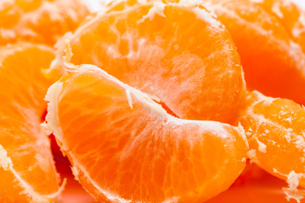 istock Peeled mandarin oranges on white background 1077310358