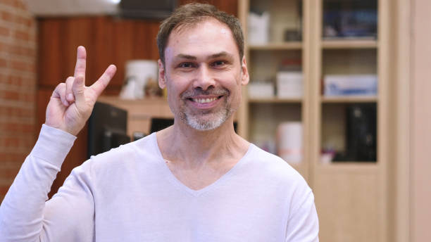 istock Victory Sign by Middle Age Man in Office 1077312448