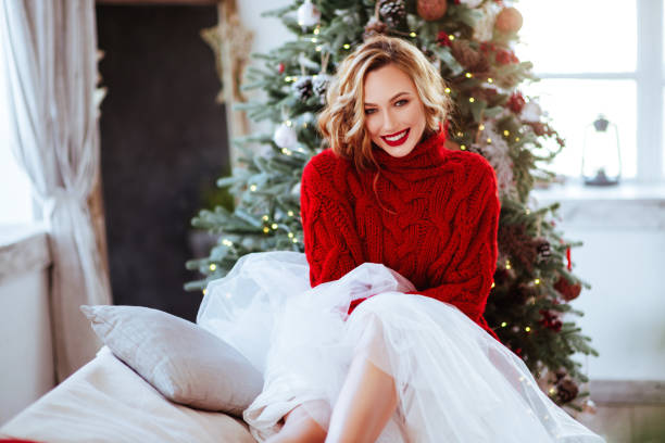 smiling woman in red sweater over christmas tree background holidays, celebration and people concept - smiling woman in red sweater over christmas tree background winter fashion stock pictures, royalty-free photos & images
