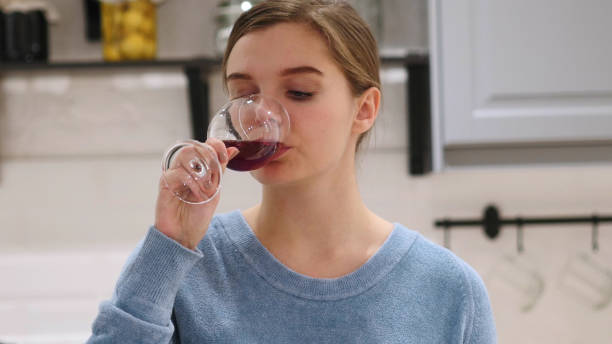 istock Young Woman Drinking Red Wine at Home, Relaxing 1077313430