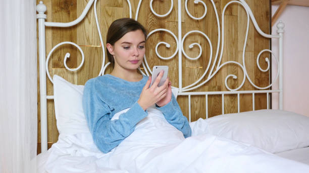 istock Tired Woman Lying in Bed Browsing on Smartphone 1077314696